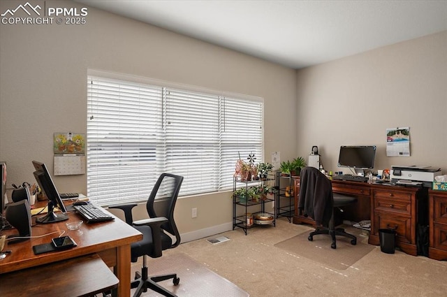 carpeted office space featuring visible vents and baseboards