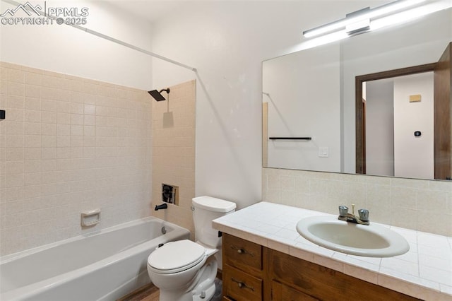 bathroom with vanity, decorative backsplash, toilet, and shower / washtub combination
