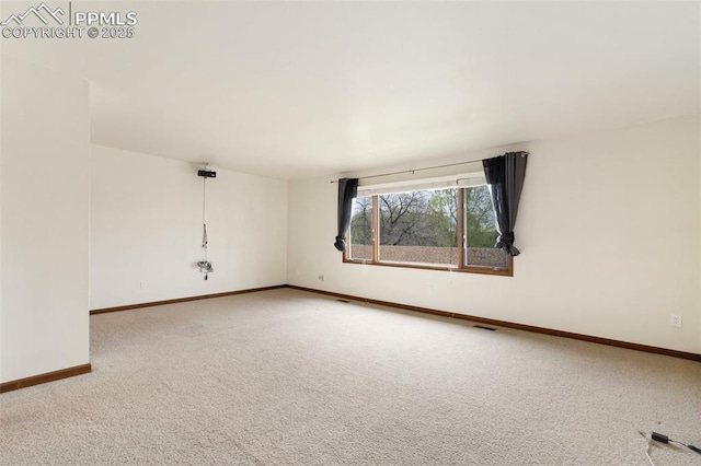 carpeted spare room with baseboards and visible vents