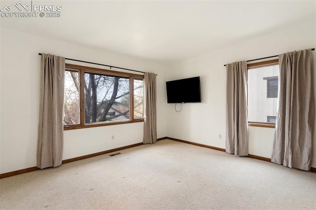 spare room featuring baseboards, carpet, and visible vents
