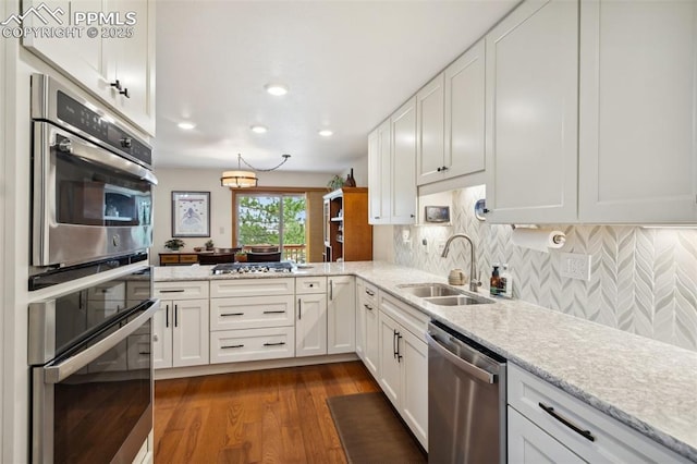 344 Mission Hill Way, Colorado Springs, CO 80921 - kitchen featuring dark wood-style flooring, a sink, stainless steel appliances, white cabinetry, and tasteful backsplash