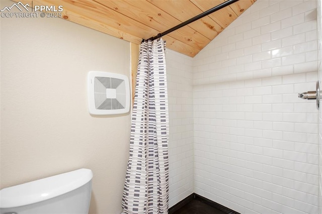 full bathroom featuring toilet, vaulted ceiling, and a tile shower