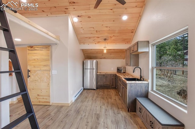 kitchen featuring a sink, baseboard heating, freestanding refrigerator, wooden ceiling, and light wood-type flooring