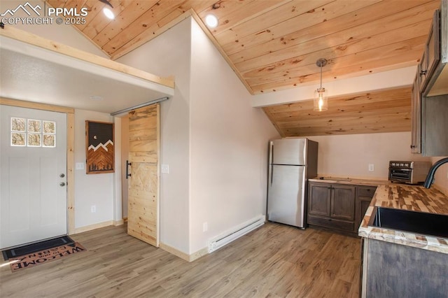 kitchen with freestanding refrigerator, a baseboard heating unit, wood ceiling, and vaulted ceiling