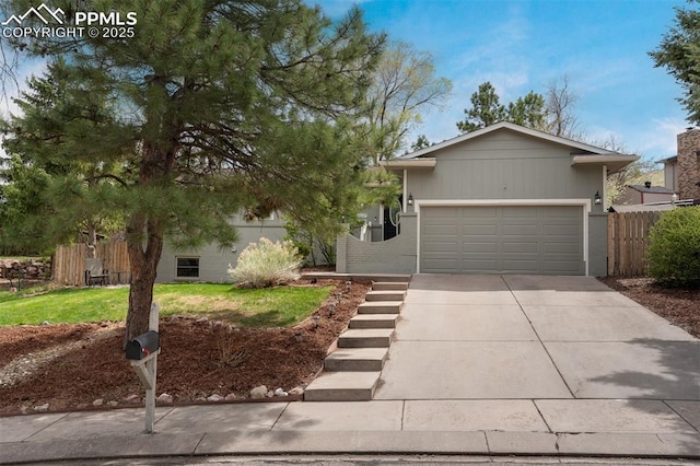 view of front of home featuring fence, driveway, and an attached garage