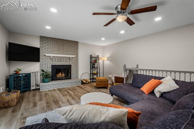 living room with recessed lighting, wood finished floors, ceiling fan, and a brick fireplace