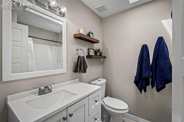 bathroom featuring toilet, curtained shower, visible vents, and vanity