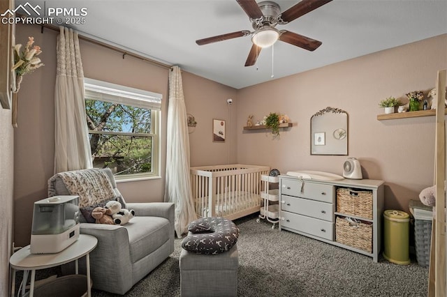 carpeted bedroom with a nursery area and ceiling fan