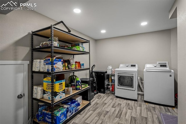 clothes washing area with recessed lighting, wood finished floors, laundry area, and washing machine and dryer