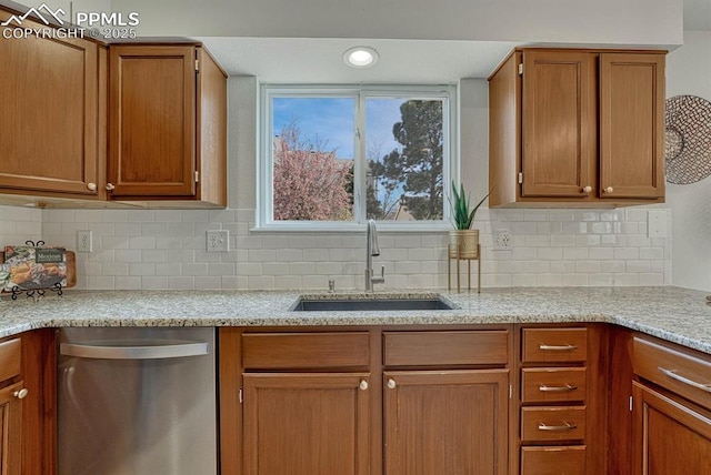 kitchen with brown cabinets, dishwasher, backsplash, and a sink