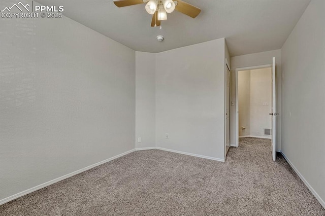 carpeted spare room with baseboards and a ceiling fan