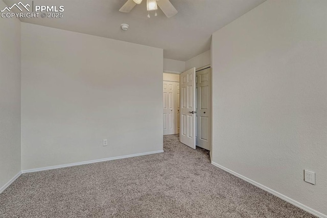 unfurnished bedroom with a closet, ceiling fan, carpet floors, and baseboards