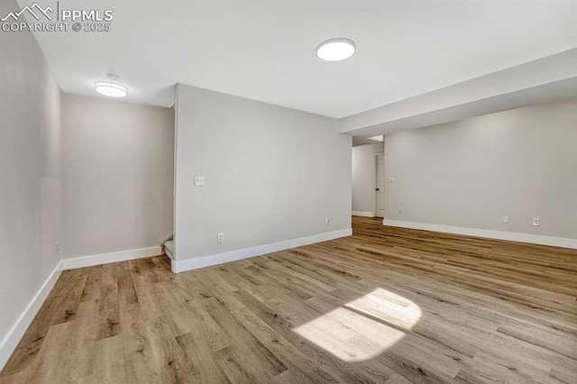 below grade area with baseboards and light wood finished floors