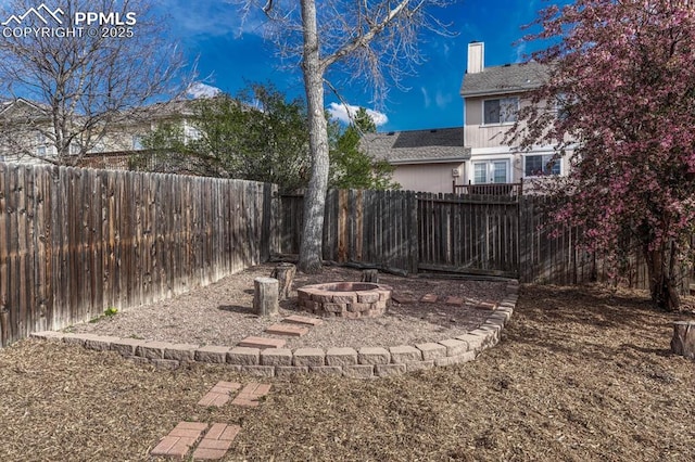 view of yard featuring a fire pit and a fenced backyard