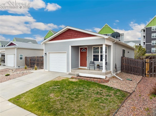 single story home with a porch, fence, driveway, and a garage