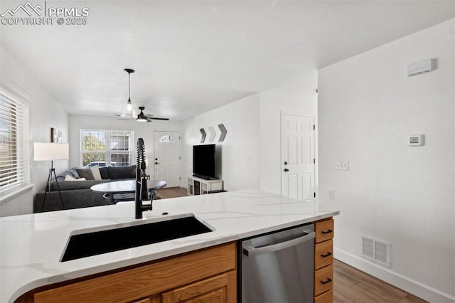 kitchen featuring stainless steel dishwasher, brown cabinetry, visible vents, wood finished floors, and ceiling fan