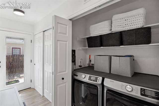 washroom featuring light wood-style floors, laundry area, and washer and dryer