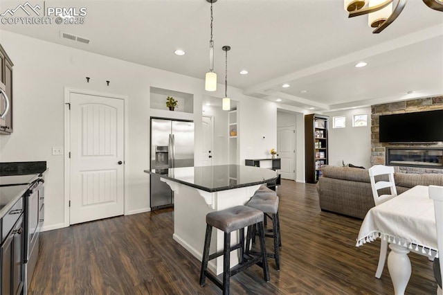 6775 Hazel Branch Ct, Colorado Springs, CO 80927 - kitchen with stainless steel refrigerator with ice dispenser, visible vents, a kitchen island, and dark wood-style flooring