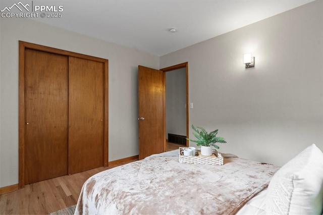 25 High St, Palmer Lake, CO 80133 - bedroom with baseboards, a closet, wood finished floors, and visible vents