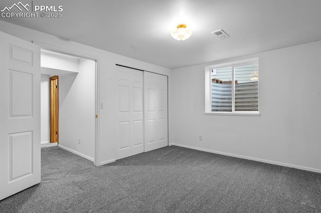 25 High St, Palmer Lake, CO 80133 - unfurnished bedroom with baseboards, a closet, dark colored carpet, and visible vents