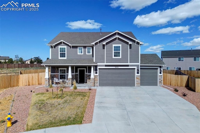 craftsman-style house with fence, stone siding, a garage, concrete driveway, and covered porch