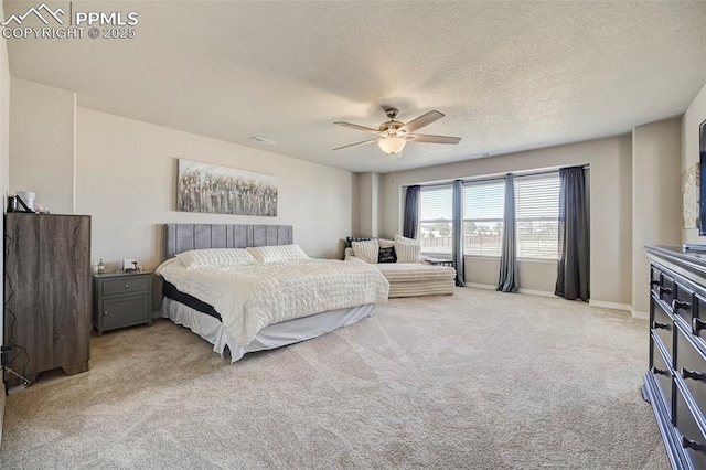 bedroom with light carpet, a ceiling fan, and a textured ceiling