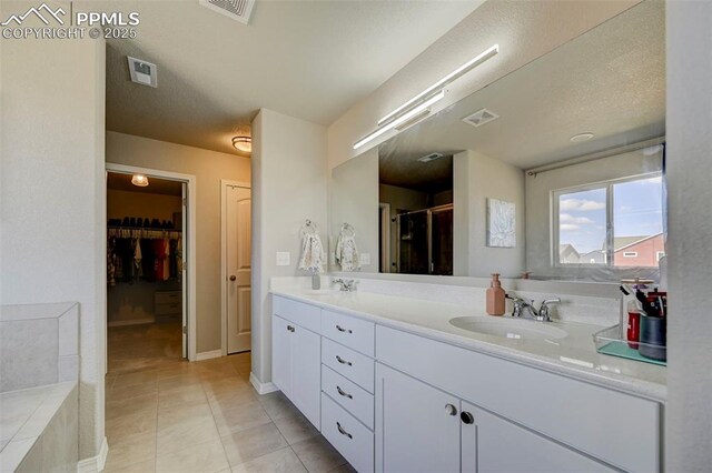 bathroom with double vanity, visible vents, and a sink