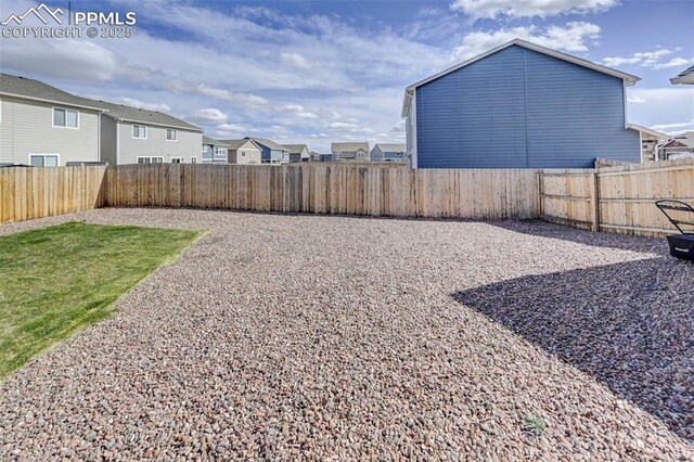 view of yard with a fenced backyard and a residential view