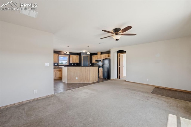 unfurnished living room featuring arched walkways, a ceiling fan, dark colored carpet, and baseboards