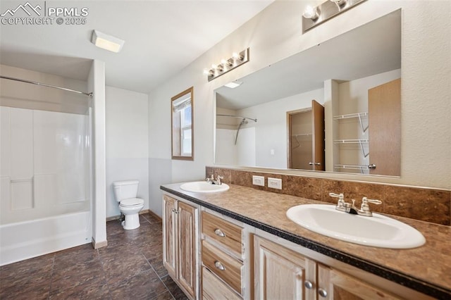 full bath featuring toilet, double vanity, a sink, and shower / bathing tub combination