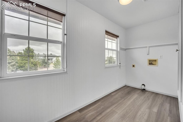 laundry area featuring hookup for an electric dryer, wood finished floors, hookup for a washing machine, and baseboards