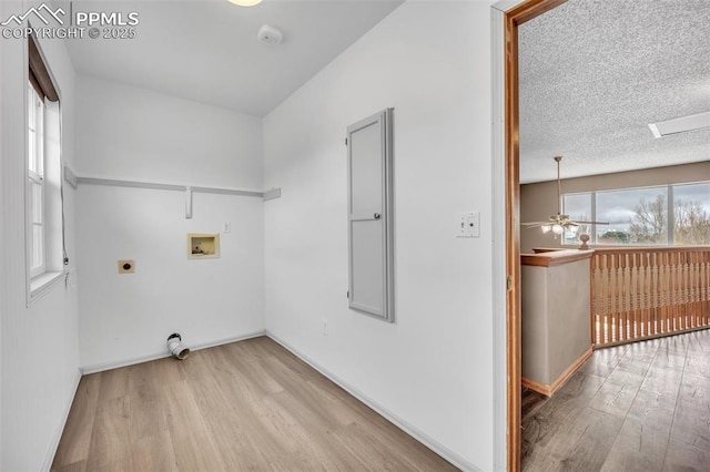laundry area featuring electric dryer hookup, hookup for a washing machine, wood finished floors, and baseboards