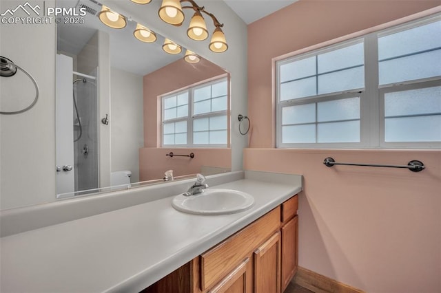 full bath featuring a shower, vanity, and toilet