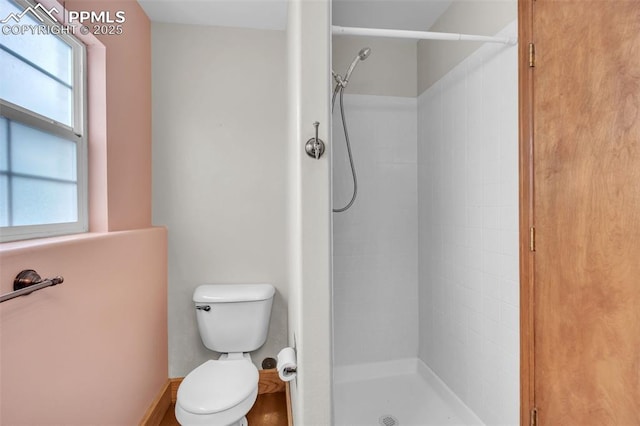 full bathroom with a tile shower and toilet