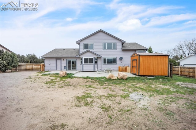 back of property featuring a patio, a shed, an outbuilding, and a fenced backyard