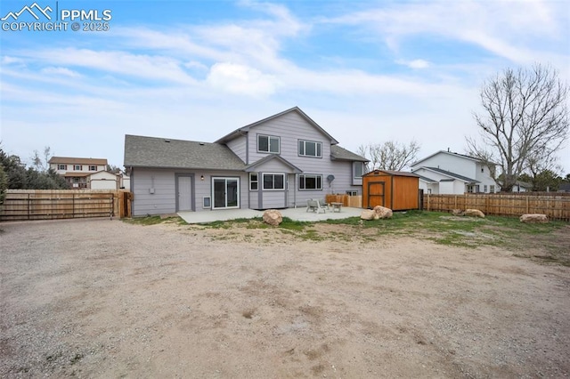 back of property with a shed, a patio area, an outbuilding, and a fenced backyard