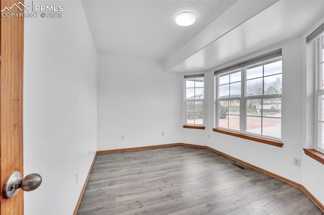 spare room with wood finished floors and baseboards