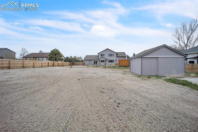 view of yard with fence and an outdoor structure