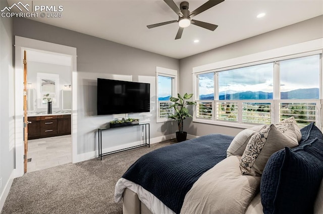 bedroom with recessed lighting, light colored carpet, ensuite bathroom, baseboards, and a ceiling fan