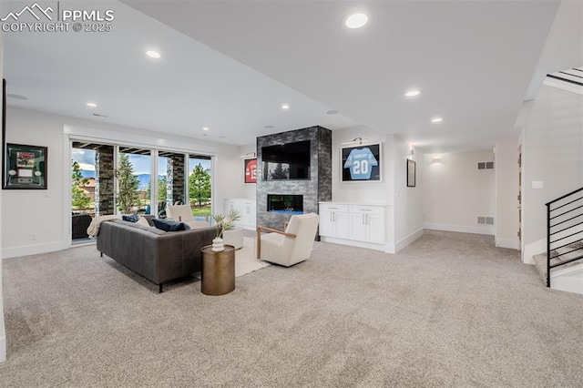 living area with stairs, light carpet, a fireplace, baseboards, and visible vents