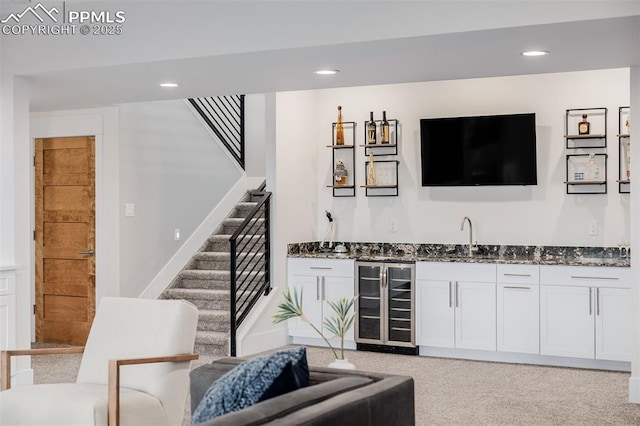 bar featuring beverage cooler, recessed lighting, stairs, indoor wet bar, and light carpet