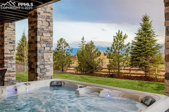 view of patio featuring a mountain view and a hot tub