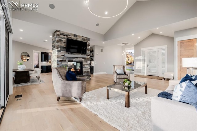 living room with recessed lighting, vaulted ceiling, light wood-type flooring, a fireplace, and visible vents