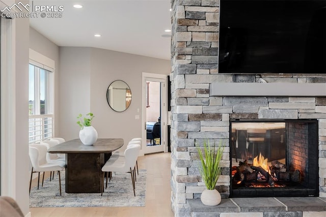 dining space with recessed lighting, wood finished floors, and a stone fireplace