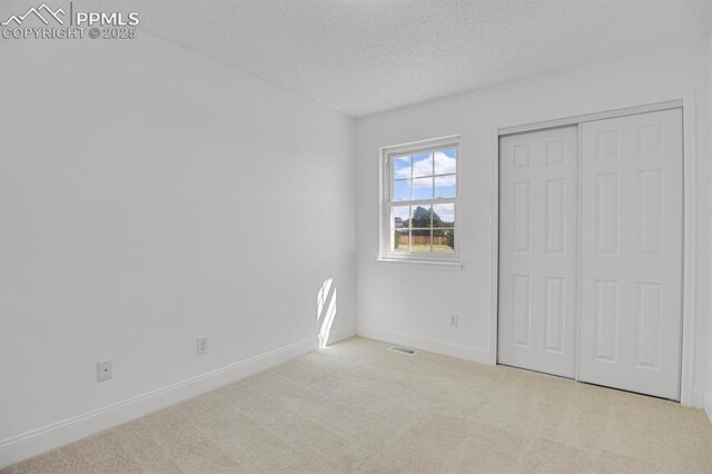 3925 Zurich Dr, Colorado Springs, CO 80920 - unfurnished bedroom with carpet flooring, a textured ceiling, baseboards, and a closet