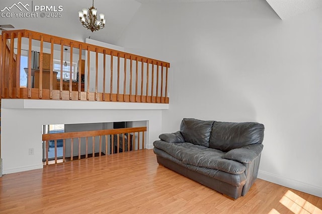 3925 Zurich Dr, Colorado Springs, CO 80920 - living area with high vaulted ceiling, a chandelier, wood finished floors, baseboards, and a fireplace