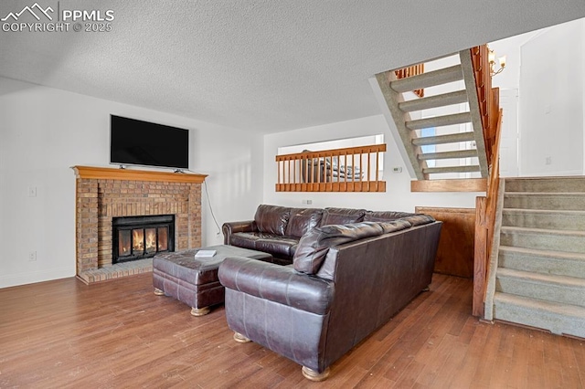 3925 Zurich Dr, Colorado Springs, CO 80920 - living area with stairs, wood finished floors, a textured ceiling, and a brick fireplace