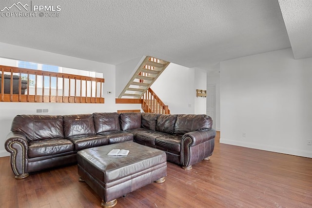 3925 Zurich Dr, Colorado Springs, CO 80920 - living area with wood finished floors, a textured ceiling, stairs, and baseboards