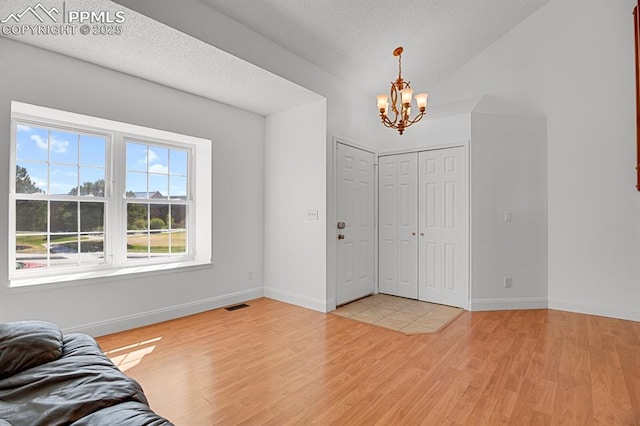 3925 Zurich Dr, Colorado Springs, CO 80920 - entrance foyer with a chandelier, light wood-style floors, baseboards, and a textured ceiling