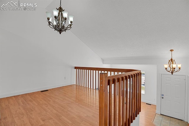 3925 Zurich Dr, Colorado Springs, CO 80920 - stairway featuring a chandelier, wood finished floors, baseboards, and vaulted ceiling